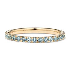 a yellow gold band with blue topaz stones on the side, and two rows of diamonds