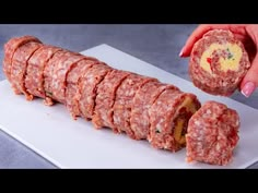 a person is cutting up some meatballs on a white platter with a knife