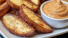 some fried food on a white plate with dipping sauce