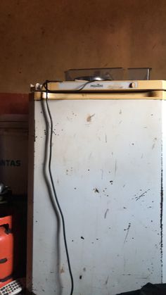 an old white refrigerator sitting in a garage