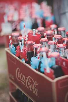 coca - cola bottles are lined up in a red crate with toothbrushes sticking out of them