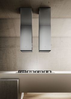 the modern sink has two stainless steel hoods over it's top burners