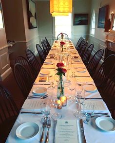 a long table set with place settings and plates