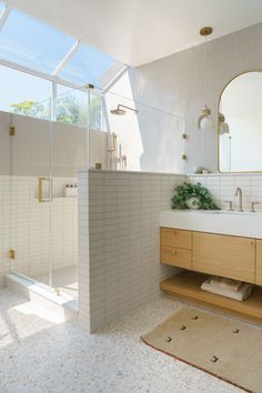 a bathroom with a sink, mirror and shower in it's own area is shown