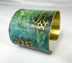 These unique, hand-formed copper and brass cuff bracelets with vibrant patinas create stunning accents to your personal style. Dress up or down- either way you'll be wearing an adornment that will turn heads, start conversations, and delight the eye of the beholder. This is a hammered cuff with bright brass peeking through a vivid marbled green/blue patina. Please note that patina colors will look different depending on the screen/device you view them on. This is a small cuff- see measurements b Luxury Traditional Metal Cuff Bracelet, Adjustable Green Cuff Bracelet, Green Patina Cuff Bracelet Gift, Green Patina Cuff Bracelet As Gift, Brass Cuff Bracelet With Patina As A Gift, Green Patina Cuff Bracelet Bangle, Green Patina Cuff Bangle Bracelet, Green Bangle Cuff Bracelet With Patina, Unique Green Metal Cuff Bracelet