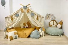 a child's room with stuffed animals on the floor and a teepee tent