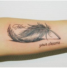 a feather with the words follow your dreams written on it's side forearm tattoo