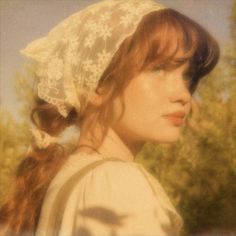 a woman with red hair wearing a white bonnet