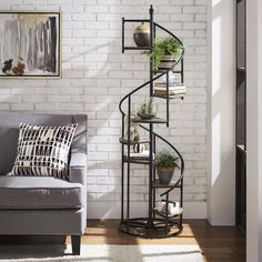 a living room with a couch, chair and spiral shelf in the corner next to a white brick wall