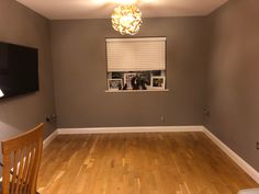 an empty room with hard wood floors and a flat screen tv mounted on the wall