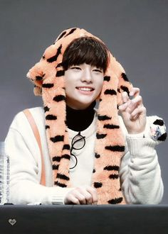 a young man wearing a tiger hat and scarf