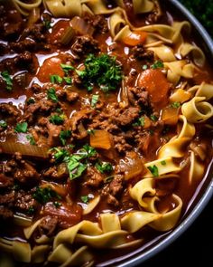 a bowl filled with pasta and meat soup