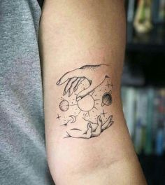 a tattoo on the arm of a person with two hands holding an earth and sun