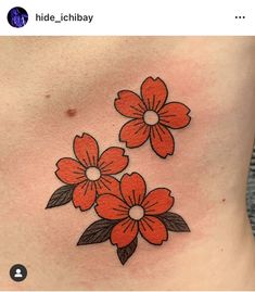 an orange flower tattoo on the back of a woman's stomach