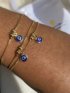 Gold Filled Evil Eye Bracelet Perfect as an accent bracelet or as a part of a stack with your other bracelets. 1mm dainty box Chain  6.5mm Evil Eye charm  The evil eye bracelet is adjustable while the herringbone bracelet has a lobster claw. Both are made from 18K Gold Filled Brazilian Gold. If you would like to purchase the herringbone alone, use the link below. https://www.etsy.com/uk/listing/914777068/18k-gold-filled-herringbone-bracelet? If you have any questions, please send me a message an Evil Eye Bracelet Gold, Blue Evil Eye Bracelet, Dainty Anklet, Herringbone Bracelet, Brazilian Gold, Turkish Eye, Gold Armband, Jewelry Accessories Ideas, Blue Evil Eye