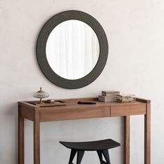 a wooden table with a mirror and stool in front of it on top of a carpeted floor