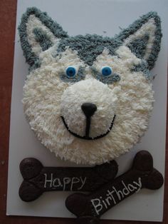 a birthday cake made to look like a dog's head and bone with the words happy birthday written on it