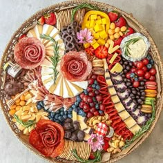 a bowl filled with lots of different types of fruit and veggies on top of a wooden floor