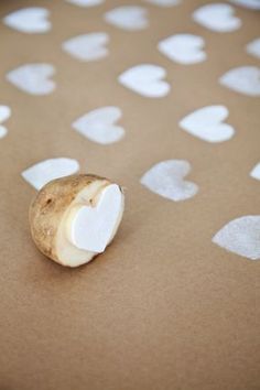 a potato sitting on top of a table covered in white hearts