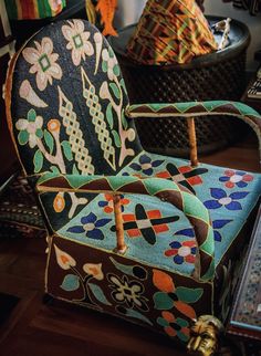 an ornately decorated chair sits in the middle of a room with other items on the floor