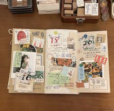 an open book with pictures and stamps on it sitting on top of a wooden table