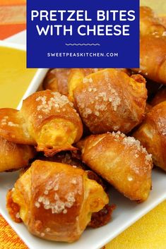 some pretzel bites with cheese are on a white plate next to a yellow towel