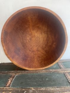 a wooden bowl sitting on top of a floor