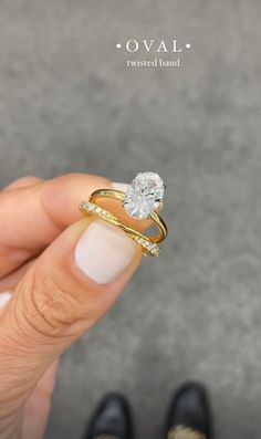 a woman's hand holding a diamond ring in front of her face and the words oval