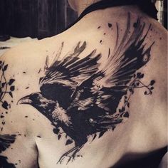 the back of a woman's shoulder with a black and white bird on it