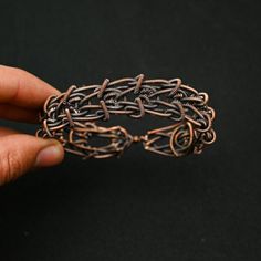 a hand holding a piece of metal wire