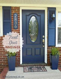 the front door is painted blue and has two planters with plants in them next to it