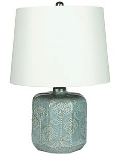 a lamp with a white shade on it and a blue vase sitting next to it