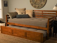 a day bed with pull out trundle and storage underneath it in a living room