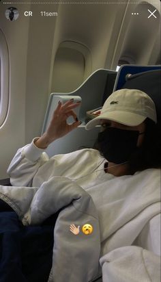 a person wearing a face mask while sitting in an airplane