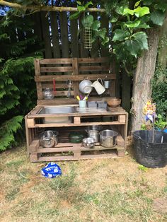 an outdoor kitchen made out of pallets and wooden crates with pots and pans