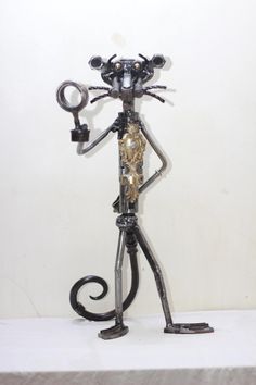 a metal cat holding a key on top of a table