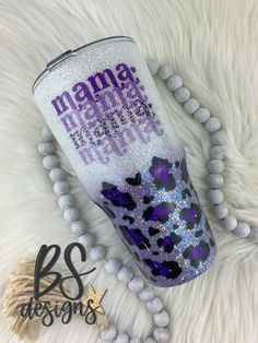 a purple leopard print tumbler with the words mama on it next to some beads