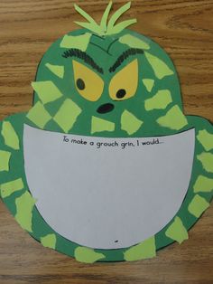 a paper cut out of a green monster holding a piece of paper with words on it