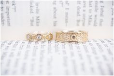 two wedding rings sitting on top of an open book