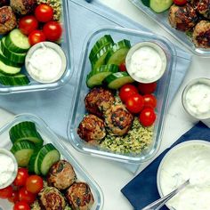 four plastic containers filled with different types of vegetables and meatballs on top of a table