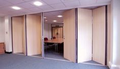 an empty office room with sliding doors on the wall and carpeted flooring in front of it