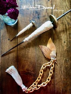 an assortment of items on a wooden table with flowers in a vase and other objects