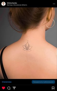 the back of a woman's neck with a lotus tattoo on it