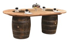 a wooden table with two wine barrels on the bottom and plates on top, sitting next to each other