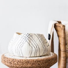 a white and black pillow sitting on top of a wooden table next to a chair