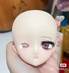 a hand holding a doll with an eye patch on it's forehead and nose