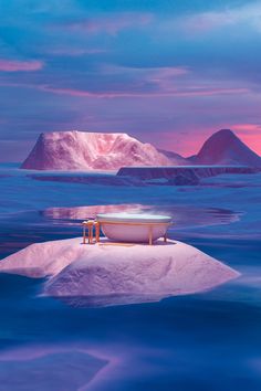 an iceberg floating in the ocean with two chairs on it