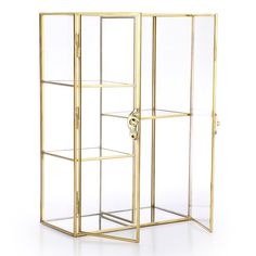 an open glass display case with gold trimmings and shelves on the sides, in front of a white background