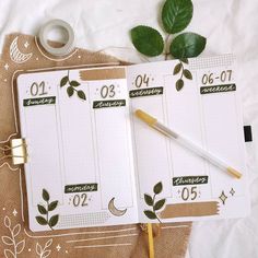 an open planner and pen sitting on top of a table