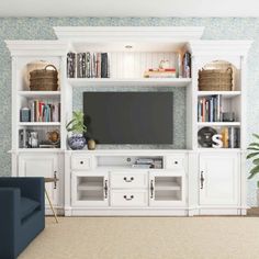 a white entertainment center with bookshelves and television on it in a living room